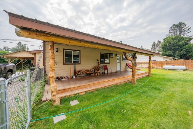 rear view of house featuring a deck and a lawn