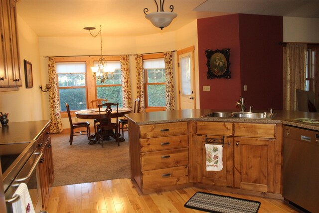 kitchen featuring dishwasher, light wood-type flooring, hanging light fixtures, and a wealth of natural light