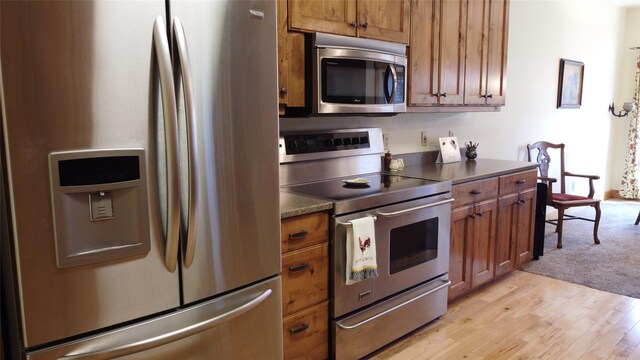 kitchen with stainless steel appliances and light hardwood / wood-style floors