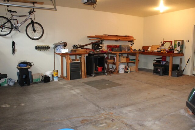 garage with a garage door opener and a workshop area