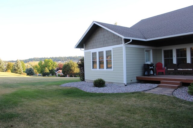 view of home's exterior featuring a wooden deck and a lawn