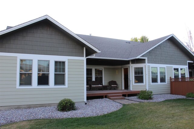 rear view of house with a lawn and a deck