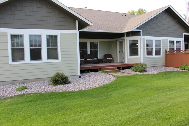 back of property featuring a lawn and a deck