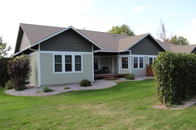 back of property featuring a deck and a yard