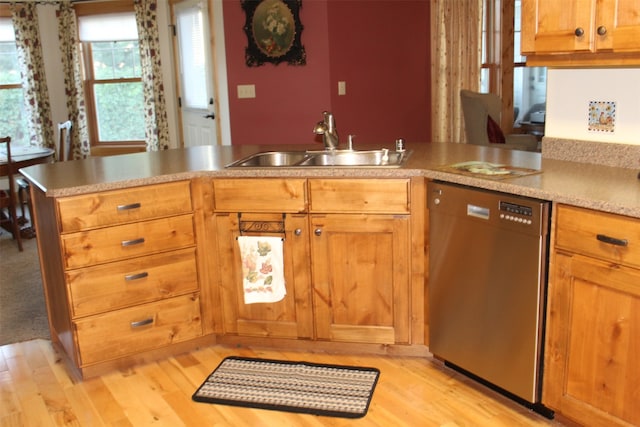 kitchen with light hardwood / wood-style floors, sink, kitchen peninsula, and stainless steel dishwasher