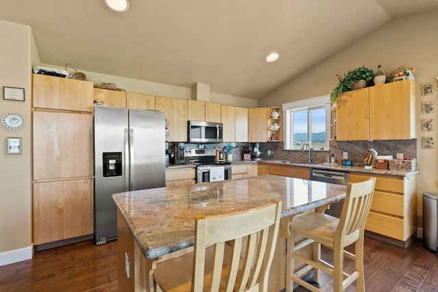 881 Lone Coyote Trl, Kalispell, MT 59901 - kitchen featuring appliances with stainless steel finishes, backsplash, light stone countertops, lofted ceiling, and recessed lighting
