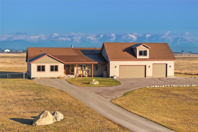 881 Lone Coyote Trl, Kalispell, MT 59901 - view of front of home featuring cooling unit, fence, driveway, a front lawn, and a garage