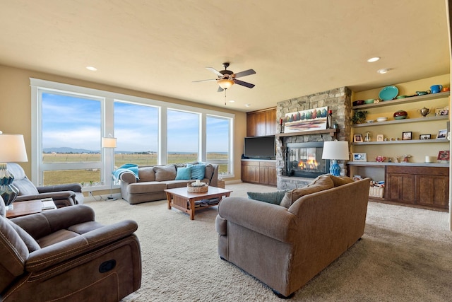 881 Lone Coyote Trl, Kalispell, MT 59901 - living area featuring light colored carpet, a ceiling fan, a stone fireplace, and recessed lighting