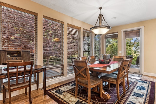 dining space featuring light hardwood / wood-style flooring and a textured ceiling