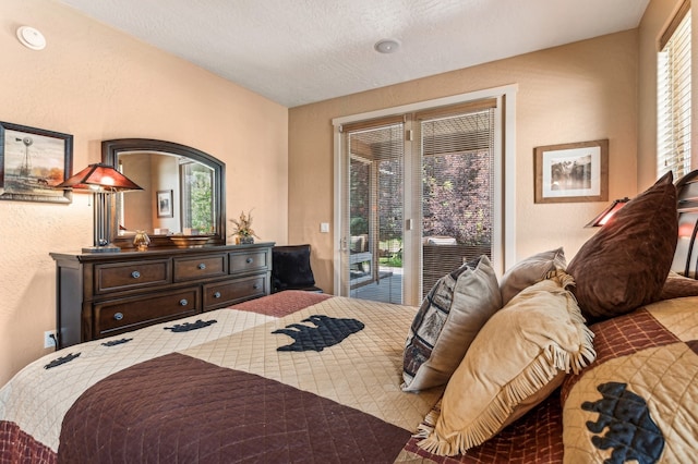 bedroom with access to outside and a textured ceiling