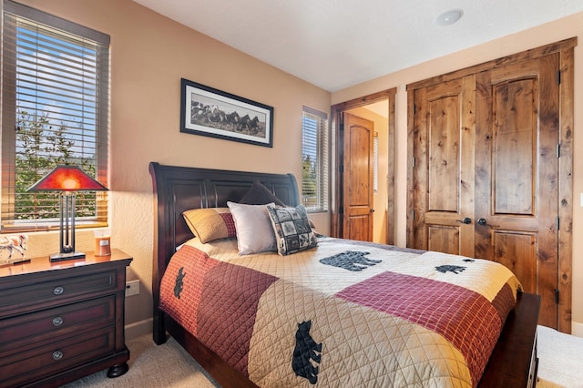 bedroom featuring a closet and light colored carpet