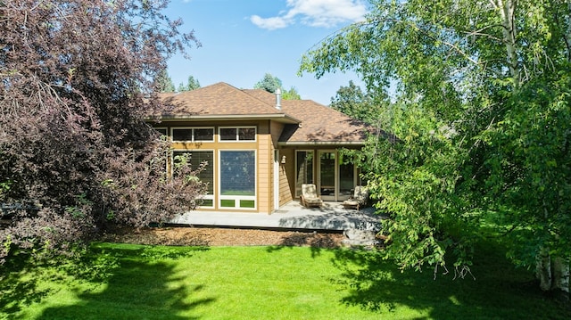 rear view of property featuring a lawn