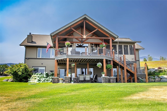 back of property featuring stairs, a yard, a chimney, and a deck