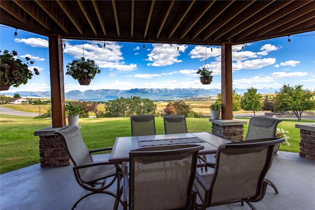 view of patio with outdoor dining area and a mountain view