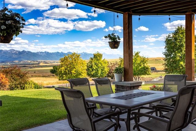 view of patio / terrace with outdoor dining space and a mountain view