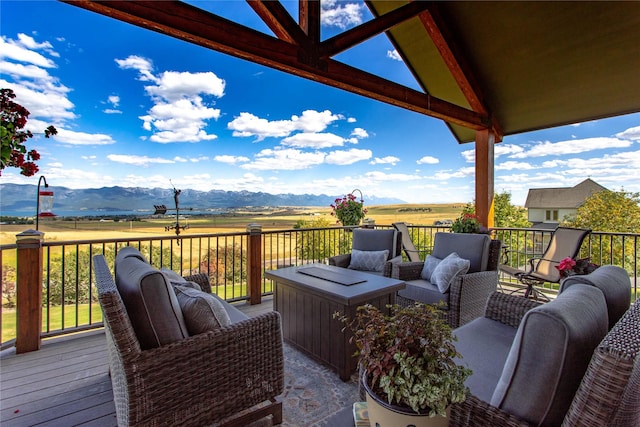 wooden terrace with a mountain view, a rural view, and an outdoor hangout area