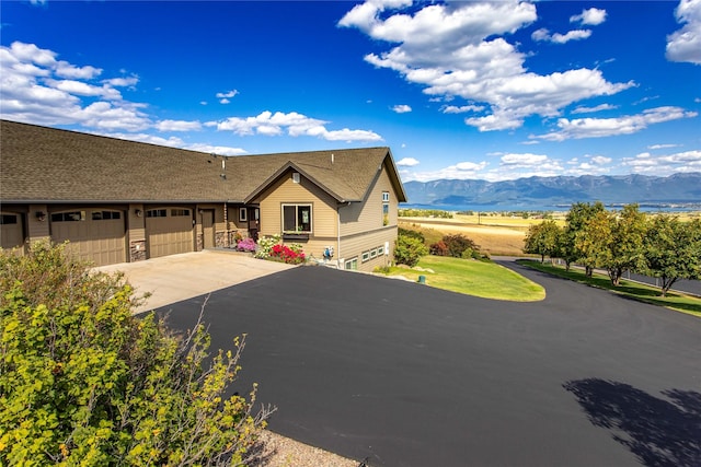 view of front facade featuring concrete driveway, a mountain view, and a garage