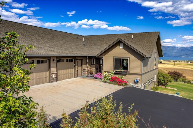 ranch-style house with an attached garage, driveway, a shingled roof, and stone siding