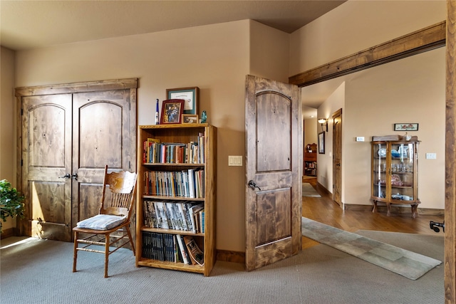living area featuring wood finished floors, baseboards, and carpet floors
