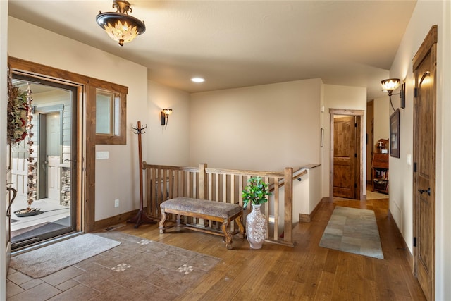 corridor featuring wood-type flooring, baseboards, and recessed lighting