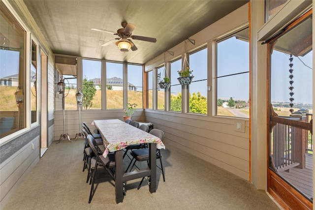 sunroom / solarium featuring outdoor dining area, a wealth of natural light, and ceiling fan