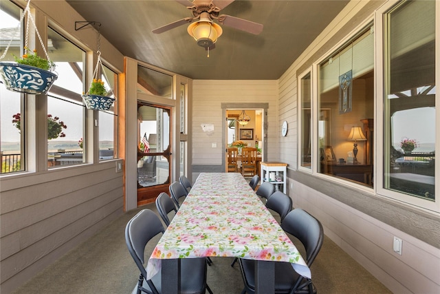 sunroom / solarium with a ceiling fan and outdoor dining space