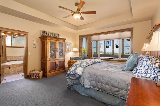 bedroom with ceiling fan with notable chandelier, ensuite bath, a tray ceiling, and carpet floors