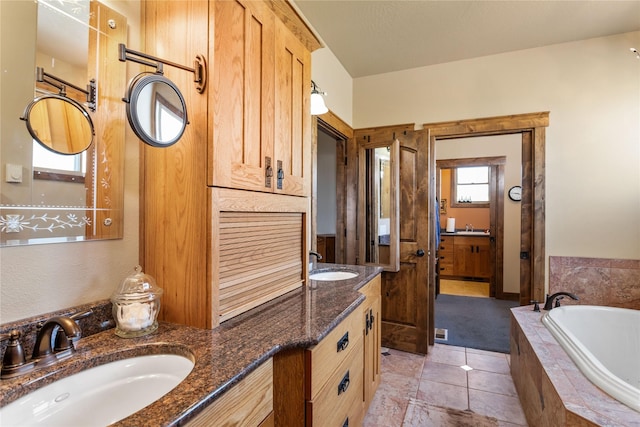 bathroom featuring a bath, a sink, tile patterned flooring, and double vanity