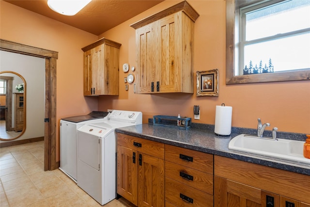 laundry room featuring cabinet space, a healthy amount of sunlight, washer and clothes dryer, and a sink