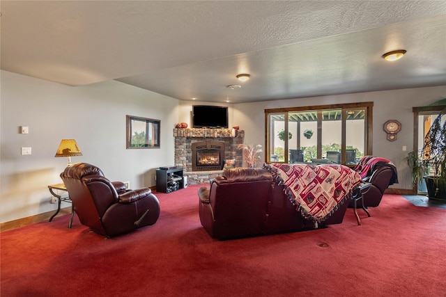 carpeted living area with baseboards, a stone fireplace, and a textured ceiling