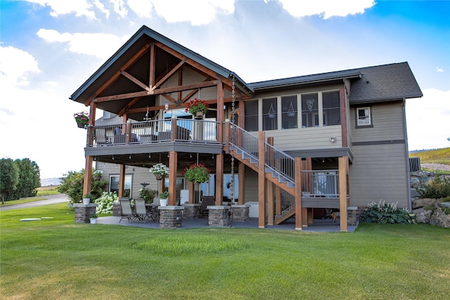 rear view of property with a lawn, a patio area, and stairs