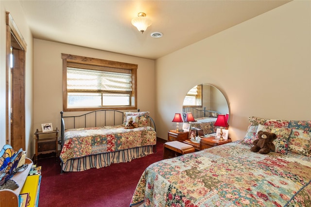 carpeted bedroom featuring visible vents