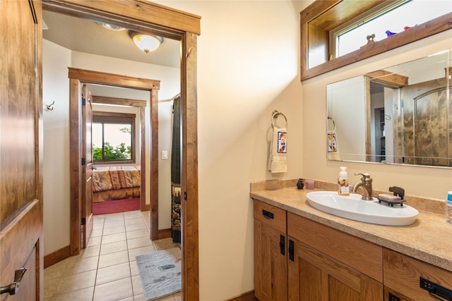 bathroom featuring connected bathroom, a wealth of natural light, vanity, and tile patterned floors
