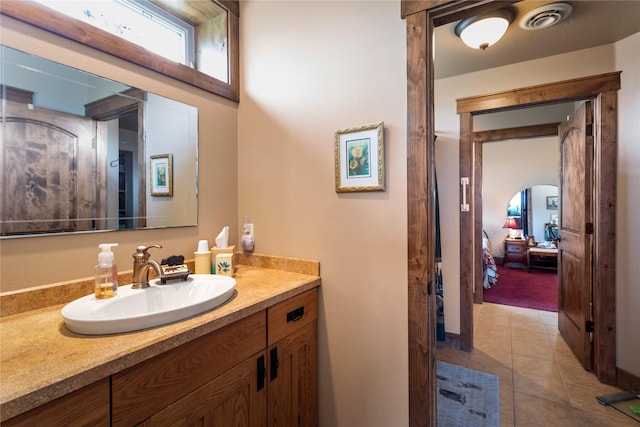 bathroom featuring vanity, tile patterned floors, visible vents, and ensuite bathroom