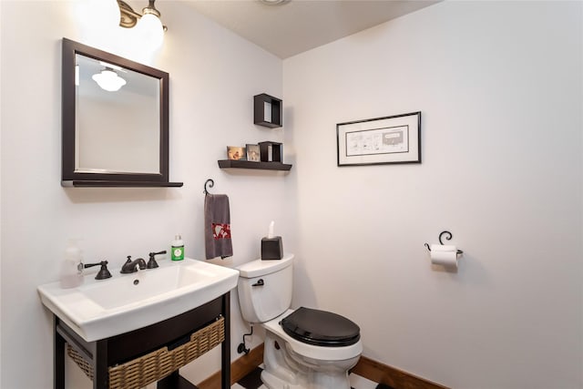 bathroom with baseboards, vanity, and toilet