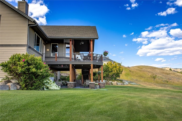rear view of property with a lawn, a chimney, a mountain view, and a patio area