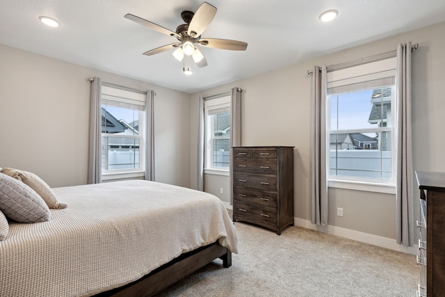 carpeted bedroom featuring multiple windows and ceiling fan