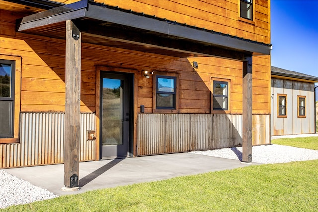 doorway to property featuring a lawn