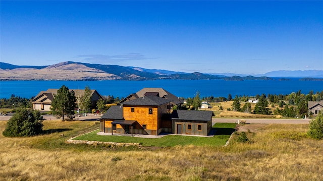 exterior space with a water and mountain view and a yard