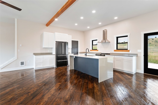 kitchen with dark hardwood / wood-style floors, ventilation hood, an island with sink, white cabinets, and high end fridge