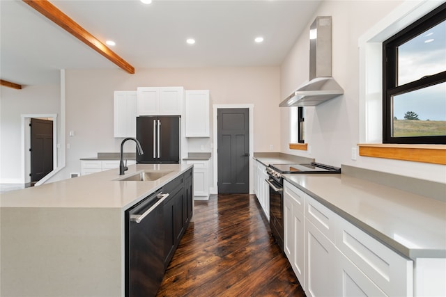 kitchen featuring an island with sink, wall chimney exhaust hood, white cabinetry, stainless steel appliances, and dark hardwood / wood-style floors