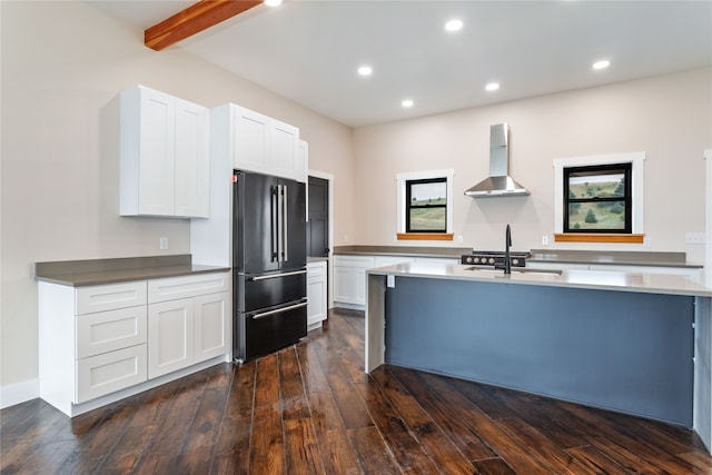 kitchen featuring wall chimney exhaust hood, high quality fridge, dark hardwood / wood-style flooring, and white cabinetry