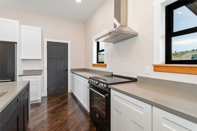 kitchen featuring white cabinetry, stainless steel refrigerator, electric range, and ventilation hood