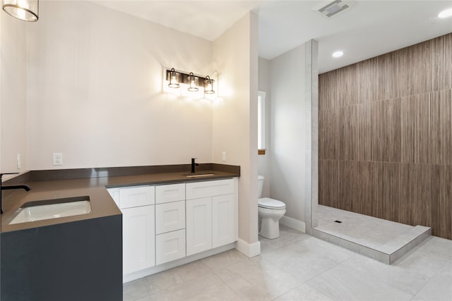 bathroom with vanity, a shower, tile patterned flooring, and toilet