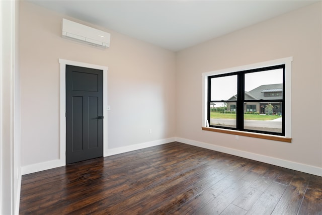 empty room featuring dark wood-type flooring and a wall unit AC