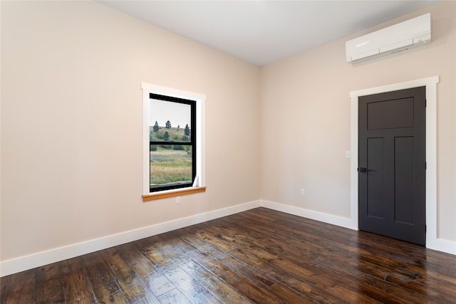 empty room featuring dark wood-type flooring and a wall mounted air conditioner