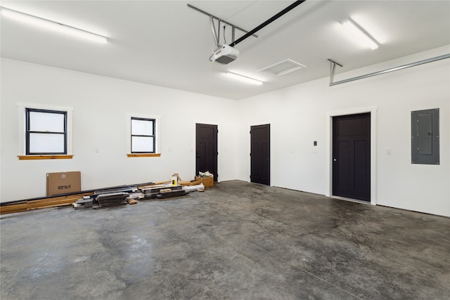 garage with a garage door opener and electric panel