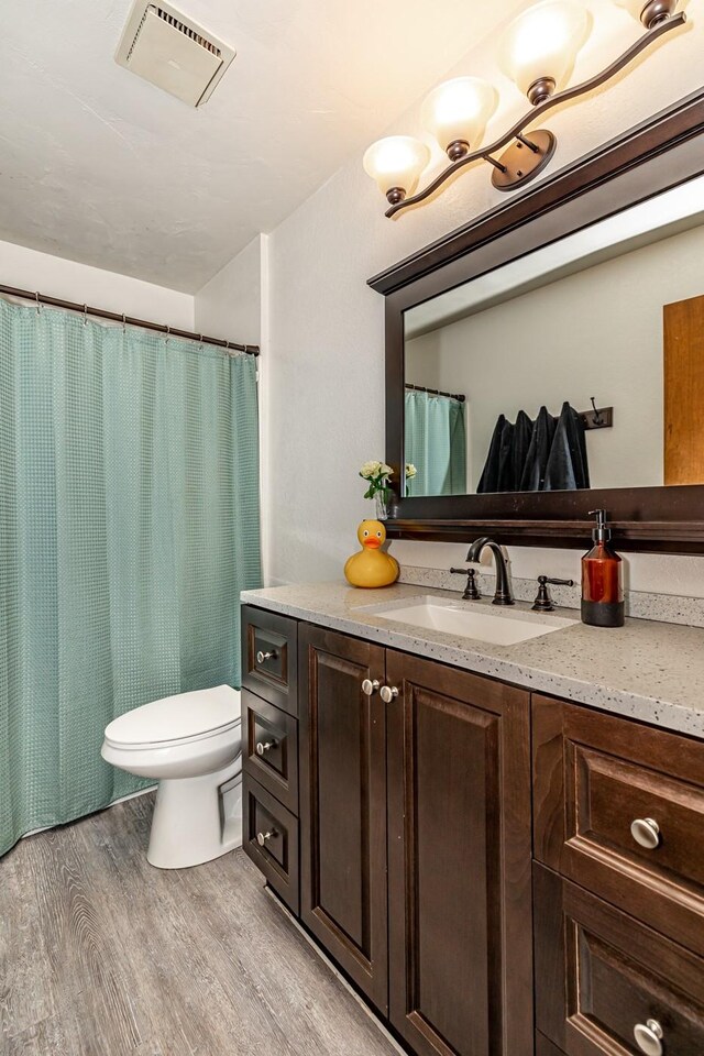 bathroom featuring hardwood / wood-style floors, toilet, and vanity