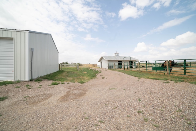 view of yard with a rural view, an exterior structure, and an outdoor structure