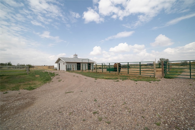 view of front of house featuring an outbuilding, an exterior structure, and a rural view